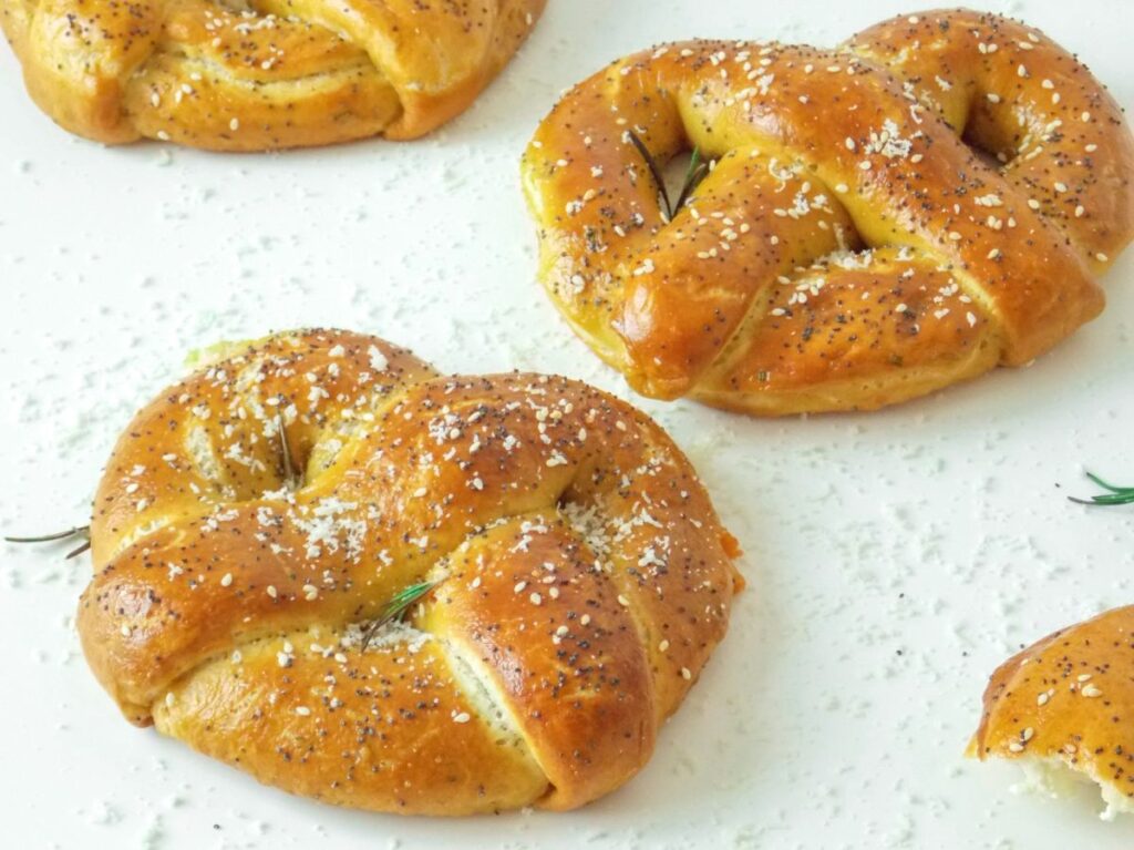 Covrigi de casă aurii și pufoși, umpluți cu brânză feta și parmezan, proaspăt scoși din cuptor