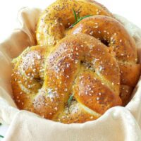 Covrigi umpluți cu brânză, rumeni și pufoși, așezați într-un coșuleț rustic, perfect copți și aurii.