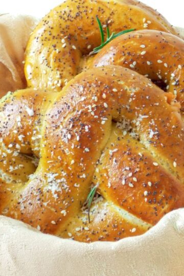 Covrigi umpluți cu brânză, rumeni și pufoși, așezați într-un coșuleț rustic, perfect copți și aurii.