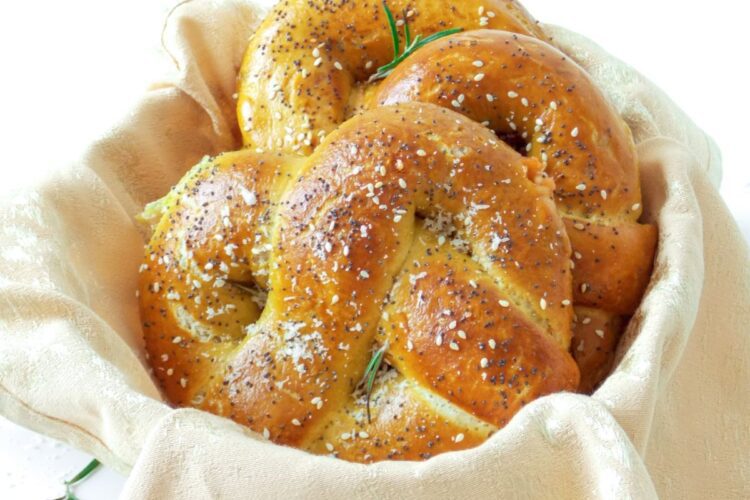 Covrigi umpluți cu brânză, rumeni și pufoși, așezați într-un coșuleț rustic, perfect copți și aurii.