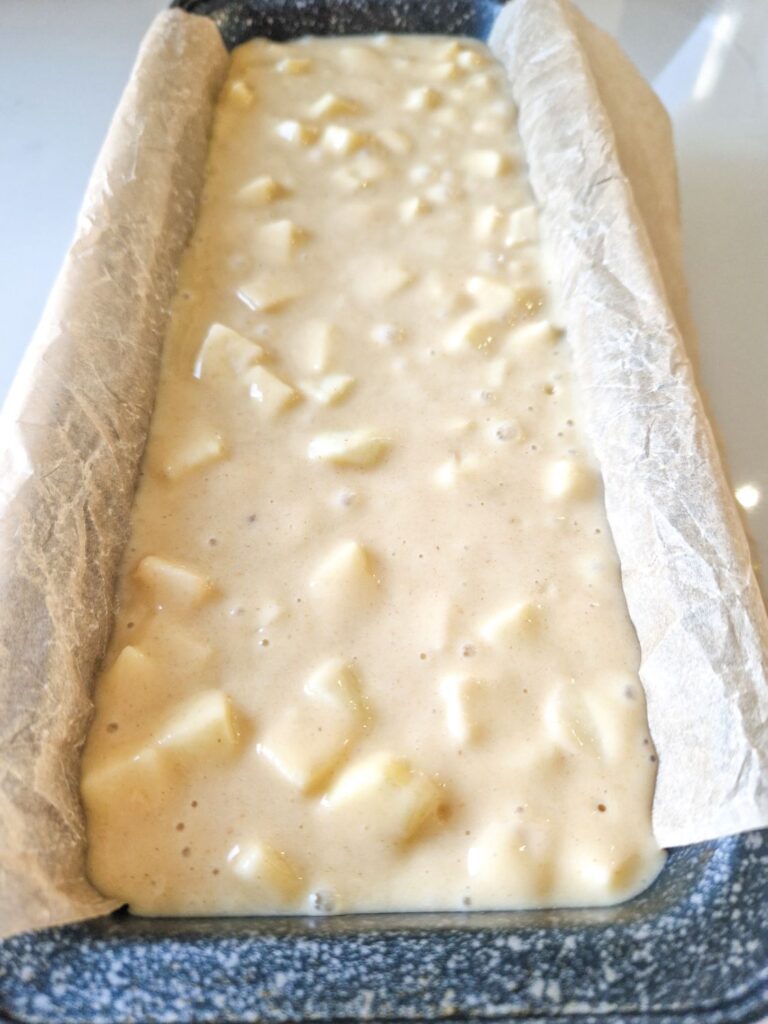 o tava generoasa de chec cu multe mere, pregatita sa mearga la cuptor