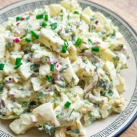 Salată de ouă cremoasă, cu țelină apio, ceapă roșie, mărar și un strop de maioneză, servită ca aperitiv sau masă ușoară.