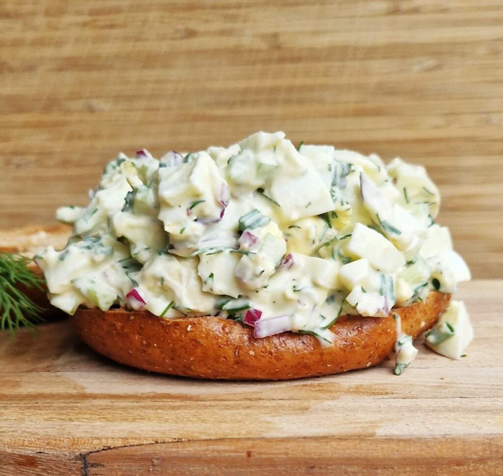 Salată de ouă cremoasă, cu țelină apio, ceapă roșie, mărar și un strop de maioneză, servită ca aperitiv sau masă ușoară.