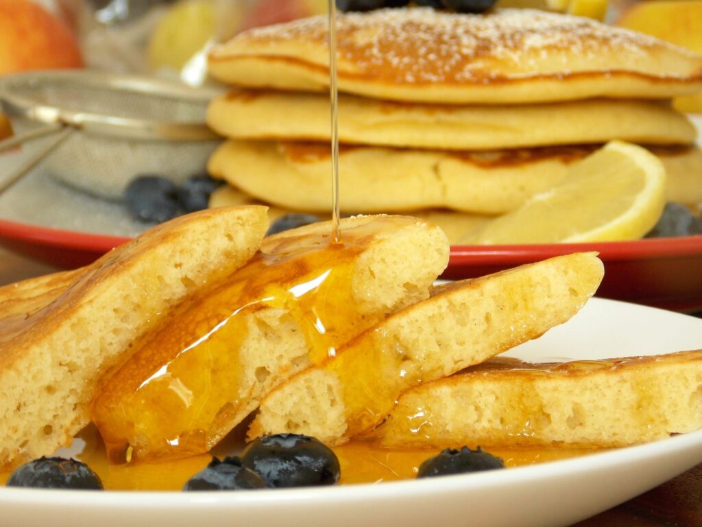 Pancakes – Clătite Americane pufoase intr-o farfurie servite cu miere si afine