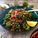 Un bol generos de salata viu colorata din spanac, quinoa, rodie, cu menta si lamaie