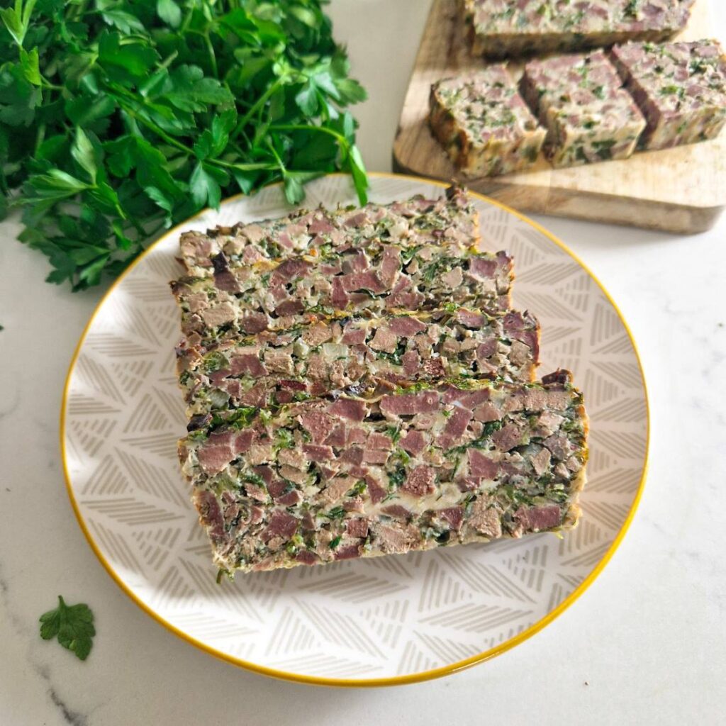 drob de miel taiat in felii maricele unde se pot vedea bucatile de carne si verdeata