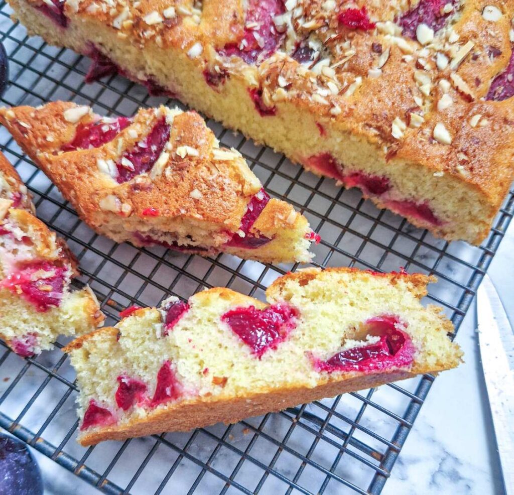 Prajitura simpla cu prune dintr-un blat foarte pufos si prune viu colorate si parfumate la interior decorata apoi cu fulgi de migdale sau nuci