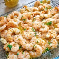 Creveți la cuptor, pregătiți cu unt topit, usturoi aromat și pătrunjel verde proaspăt, o rețetă rapidă și delicioasă.