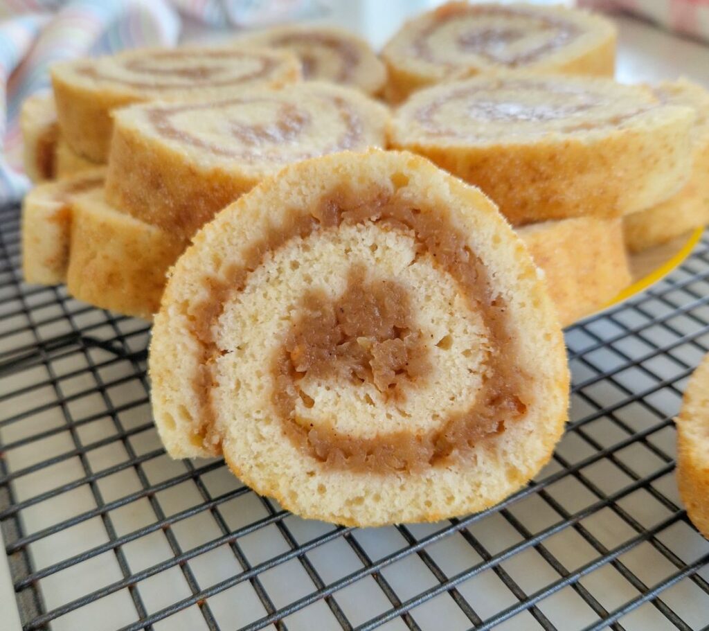 Felie de ruladă cu mere, evidențiind stratul de mere caramelizate din interior.