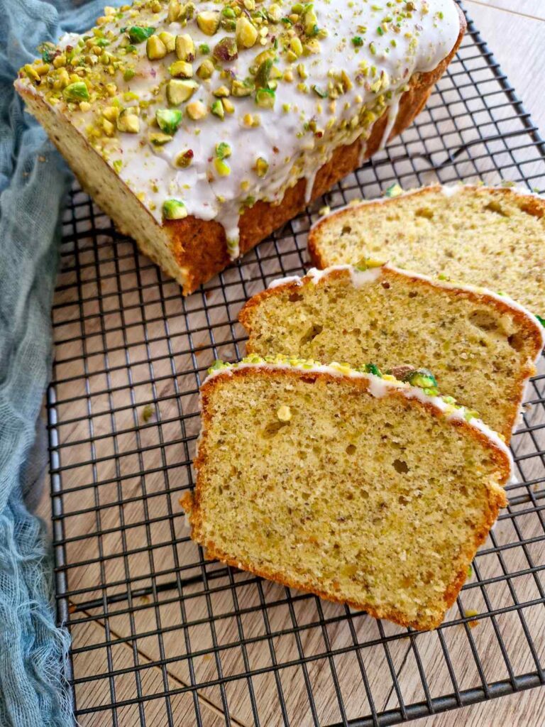 Chec cu fistic feliat, interior pufos, cu glazură albă și decor crocant