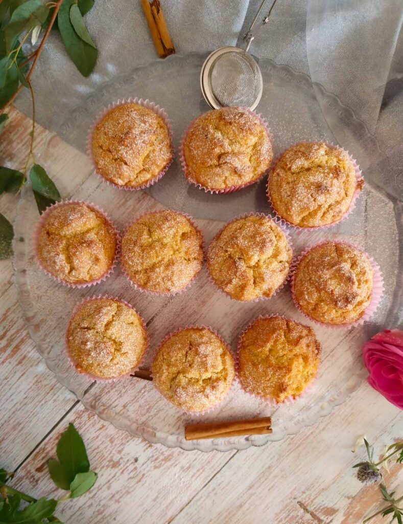 Brioșe pufoase cu dovleac – rețetă de toamnă, briose pe un suport de sticla, cu un praf de zhar pudra si decor cu scortisoara si frunze verzi