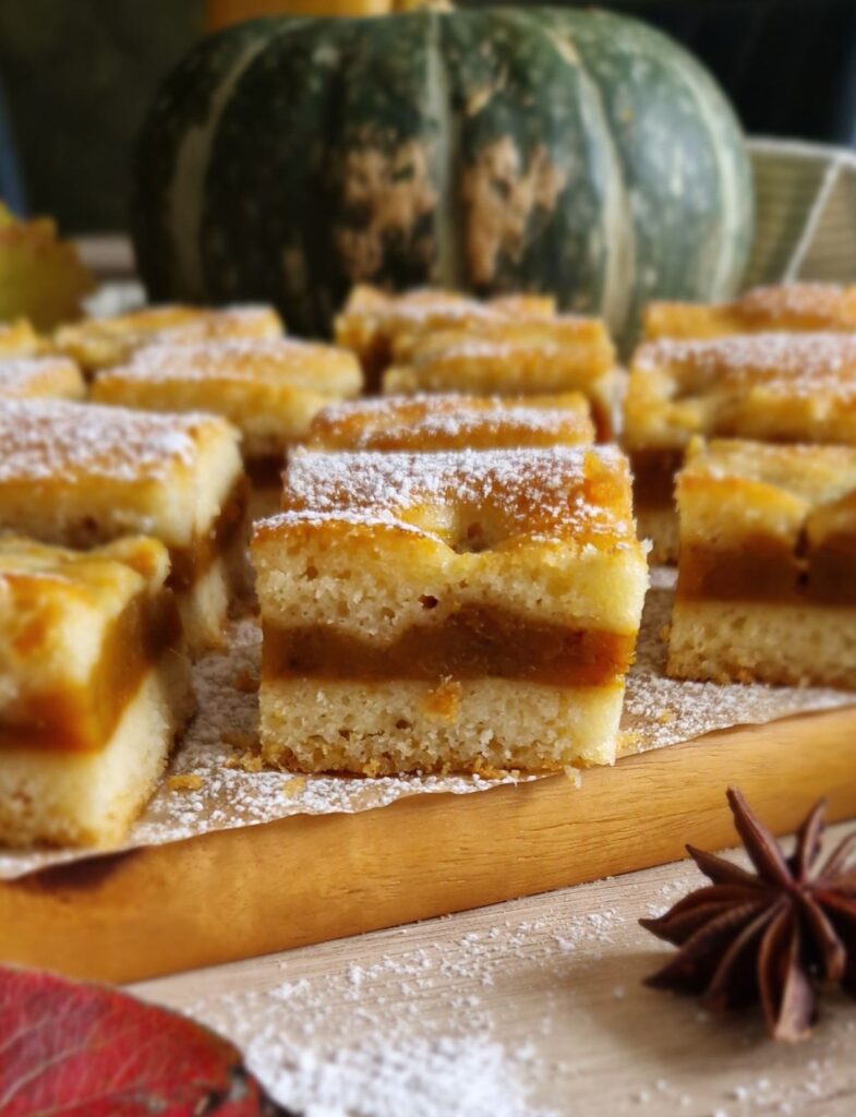 Secțiune de prăjitură turnată cu dovleac, moale și aromată, pudrată cu zahăr