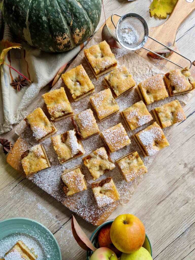 Secțiune de prăjitură turnată cu dovleac, moale și aromată, pudrată cu zahăr