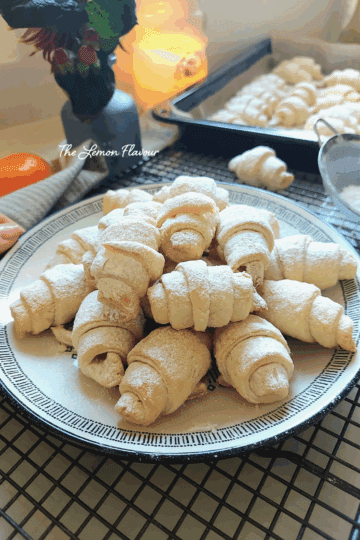 Cornulețe fragede cu untură și smântână, prezentate pe o farfurie, aproape, cu straturi delicate care se topesc în gură.