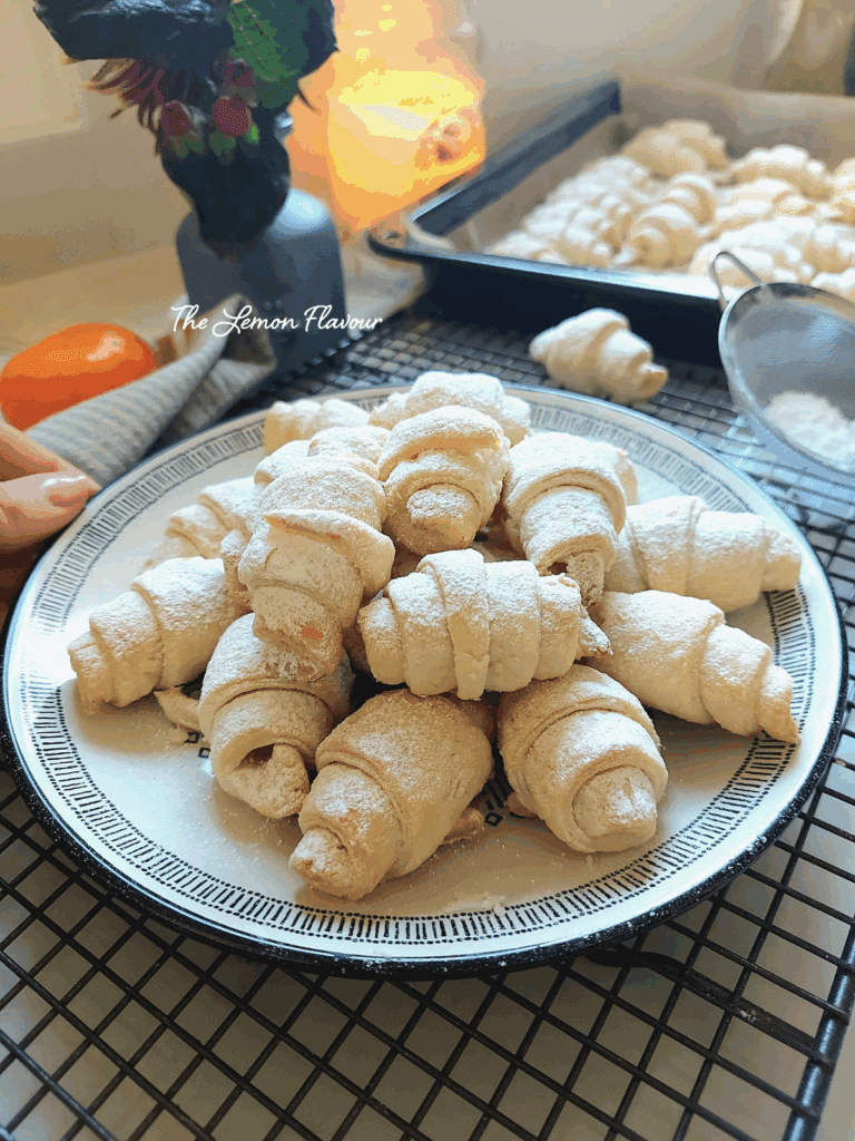 Cornulețe fragede cu untură și smântână, prezentate pe o farfurie, aproape, cu straturi delicate care se topesc în gură.