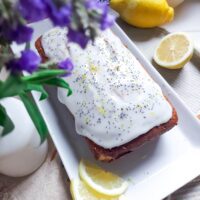 Chec umed cu lămâie și mac, întreg, proaspăt scos din tavă, cu coaja de lămâie vizibilă și culoare aurie apetisantă.