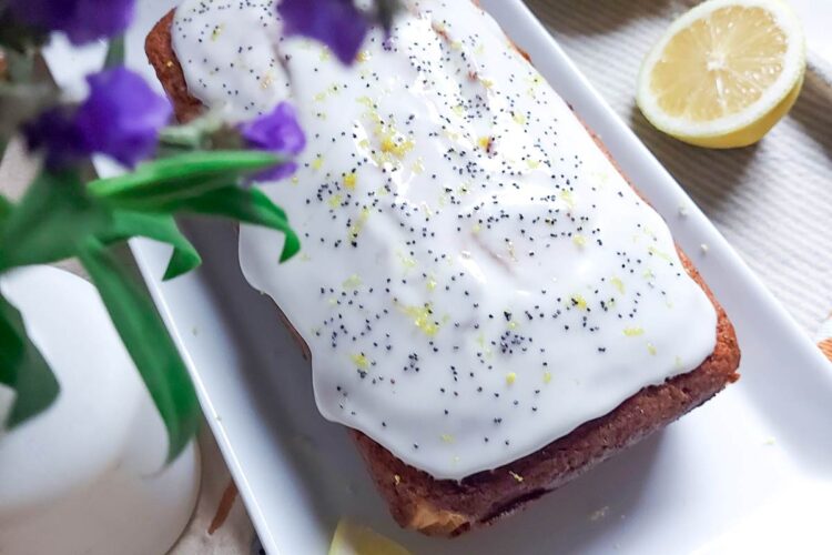 Chec umed cu lămâie și mac, întreg, proaspăt scos din tavă, cu coaja de lămâie vizibilă și culoare aurie apetisantă.