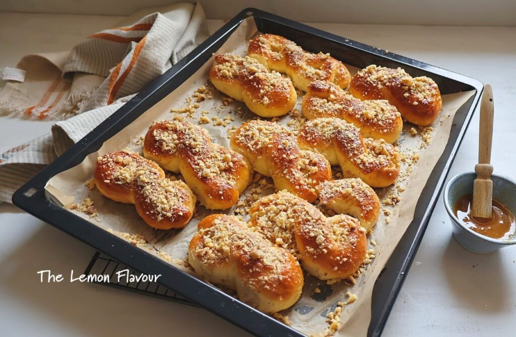 Mucenici tradiționali în tavă, pufoși, cu miere lucioasă și nucă măcinată, fotografiați de sus