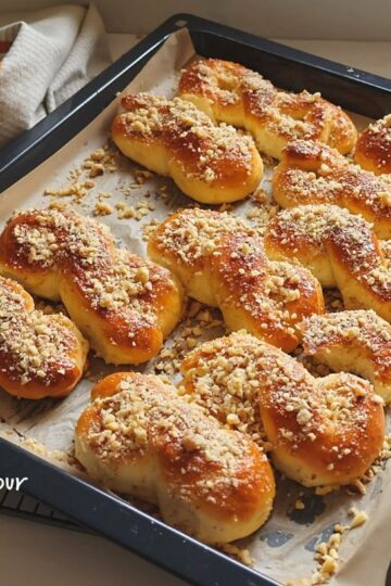 Mucenici tradiționali în tavă, pufoși, cu miere lucioasă și nucă măcinată, fotografiați de sus