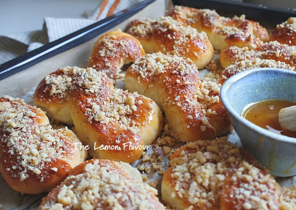 Mucenici moldovenești pufoși, ungeți cu miere și presărați cu nucă, apropriere din lateral